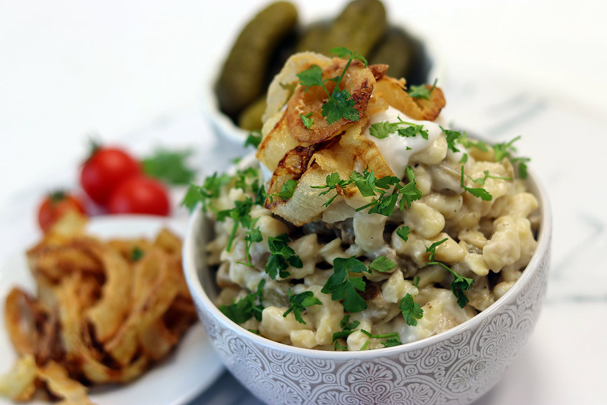 Home-made spaetzle noodles with aubergine sauce and crispy onion rings